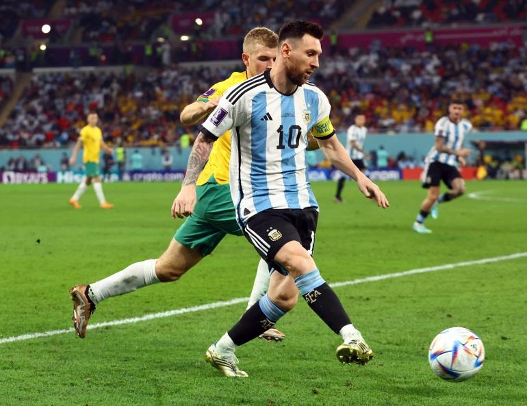 Lionel Messi din Argentina în acțiune cu Riley McGree din Australia.